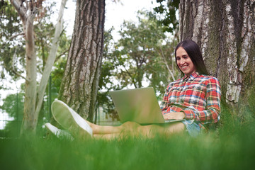 Sticker - Young dark-haired woman enjoys nature while working with laptop