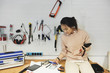 © Maskot - Businesswoman using smart phone while working in workshop