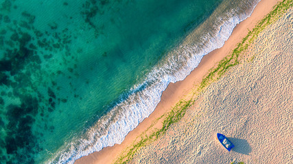 Aerial view of ocean waves and sand on beach