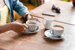 © EdNurg - Two cups of coffee with woman hands on the wooden table in cafe