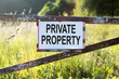 Sign Private Property on a metal gate on the dirt road