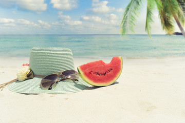 Wall Mural - Summer vacation concept straw hat with sunglasses and melon fruit on sandy tropical beach