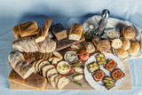 Fototapeta Fototapety do kuchni - Stół zastawiony chlebem, warzywami, smalcem i przyprawami na śniadanie w kompozycji na tle obrusu
