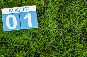 Wall Mural - August 1st. Image of august 1 wooden color calendar on green grass lawn background. Summer day. Empty space for text