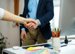 © vladstar - Businessman and businesswoman shaking hands in office