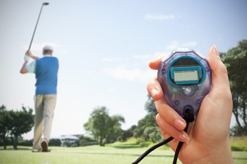 Poster - Composite image of close up of woman is holding a stopwatch in front of golf player