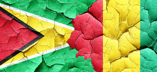 Guyana flag with Guinea flag on a grunge cracked wall