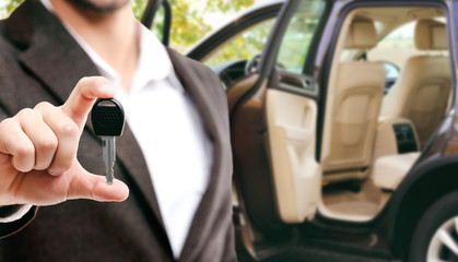 Wall Mural - Modern car with open door and businessman holding car key