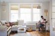 © Cavan Images - Father and daughter sitting on chair at home