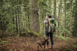 © Cavan Images - Rear view of hiker photographing in forest