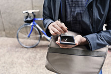 Midsection Of Male Commuter Using Smart Phone On Sidewalk