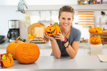 Wall Mural - Woman with ceramic pumpkin in halloween decorated kitchen