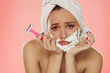 disappointed young woman with foam on the face and a razor in her hand
