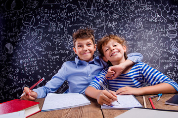 School boy and girl at the desk, big blackboard