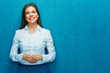 © Yuriy Shevtsov - Smiling young business woman portrait on blue wall background.
