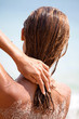 © plprod - femme sur le sable qui touche ses cheveux mouillés