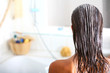 femme dans sa salle de bain soignant ses cheveux