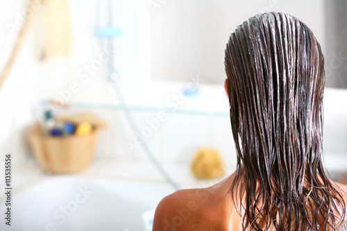 Fotografía femme dans sa salle de bain soignant ses cheveux