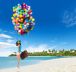 © Jag_cz - Happy woman holding balloons and suitcase on beach