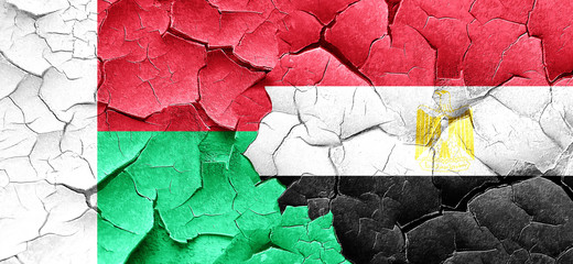 Madagascar flag with egypt flag on a grunge cracked wall