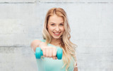 Fototapeta Łazienka - smiling beautiful young sporty woman with dumbbell