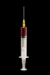 Syringe with blood on a black background