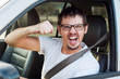 © getup_studio - Male white angry driver is showing his fist and mad face