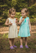 Two Little Girls In The Forest Holding Mushrooms