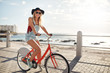 © Jacob Lund - Happy young woman riding her bike at the waterfront