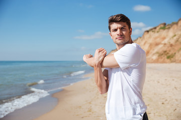 Sticker - Confident young sportsman doing exercises on the beach