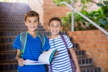 Wall Mural - School kids holding a book on staircase