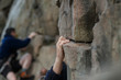 Hand of male rock climber clings to a cliff