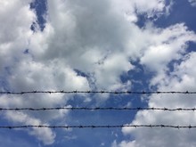 Barbed Wire On Cloudy Sky Background