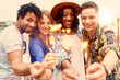 © AYAimages - Multi-ethnic millenial group of friendsfolding sparklers on rooftop terrasse at sunset