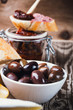 Olives calamata in ceramic bowl on wooden table
