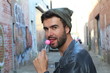 Man licking a pink shiny lollipop
