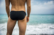© theartofphoto - Back view of man in trunks against of seascape