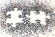 Large group of people forming a puzzle symbol