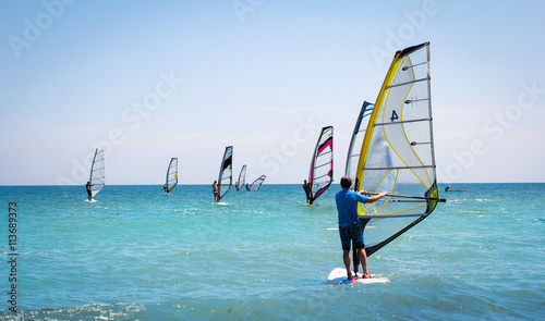 Obraz Dibond Żagle windsurfingowe na błękitnym morzu
