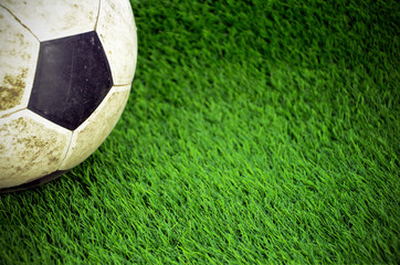 Shabby soccer ball on artificial turf field.