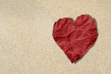 Red heart crumpled paper on sand texture, beach lover texture background