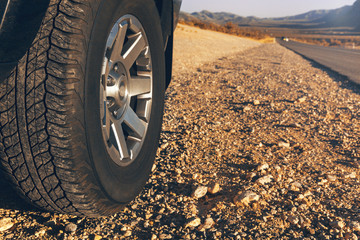 Car tire on dirt road at sunset time