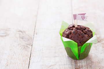 Wall Mural - Chocolate muffin for party or birthday on a wooden background with copy space..