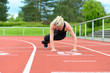 © michaelheim - Athletic woman warming up hip muscles at track