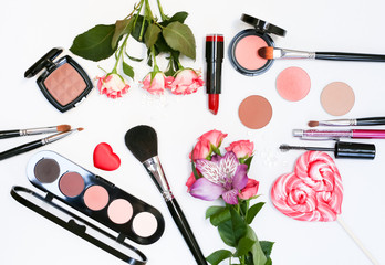 Composition with makeup cosmetics, brushes, shadoes and flowers on white background