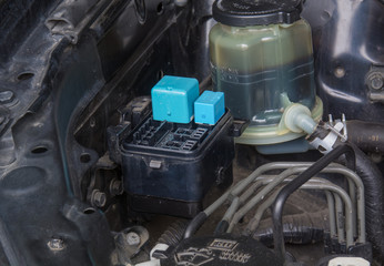 Close up of a fuse block and a power steering fluid reservoir