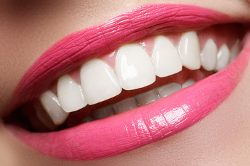 macro happy woman's smile with healthy white teeth, bright pink .lips make-up. stomatology and beaut
