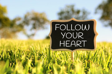 Wall Mural - Wooden chalkboard sign with quote: FOLLOW YOUR HEART