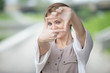 © fizkes - Portrait of playful beautiful caucasian woman pretending to take photo with her hands while walking on the street. Attractive model posing, using hands to make a frame outdoors in summer