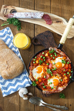 Baked Eggs With Chorizo, Potatoes And Tomatoes In A Pan On The Table. Top View